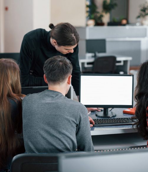 Screen with white color. Put your text there. Group of young people in casual clothes working in the modern office.